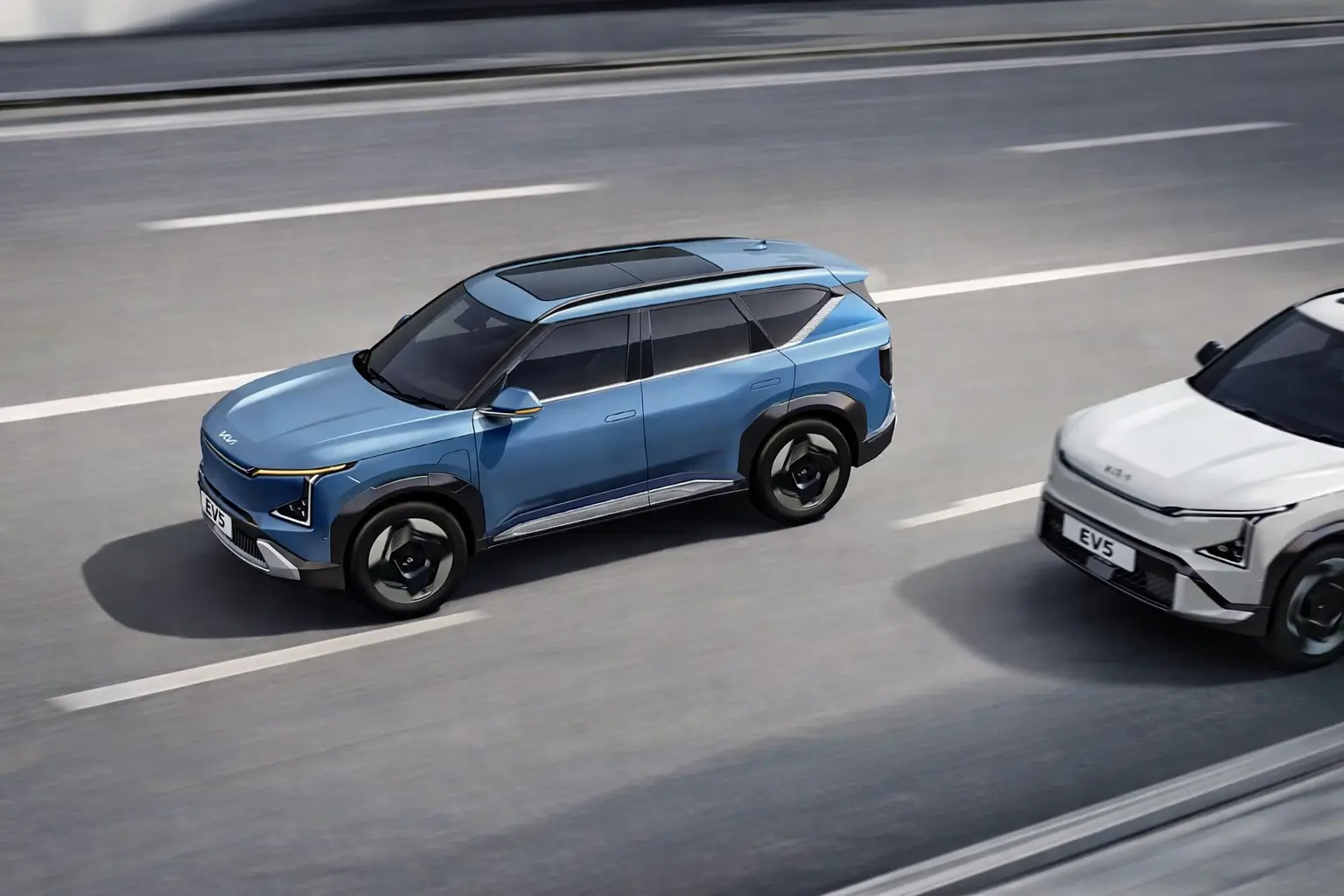 Two Kia EV5 electric SUVs in a road