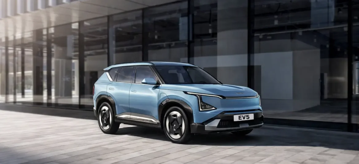 A light blue color Kia EV5 electric SUV in a urban street