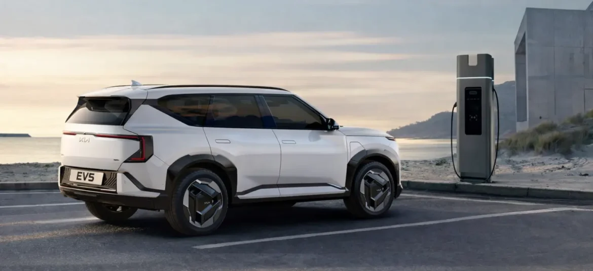A Kia EV5 electric SUV parked near a electric charging station