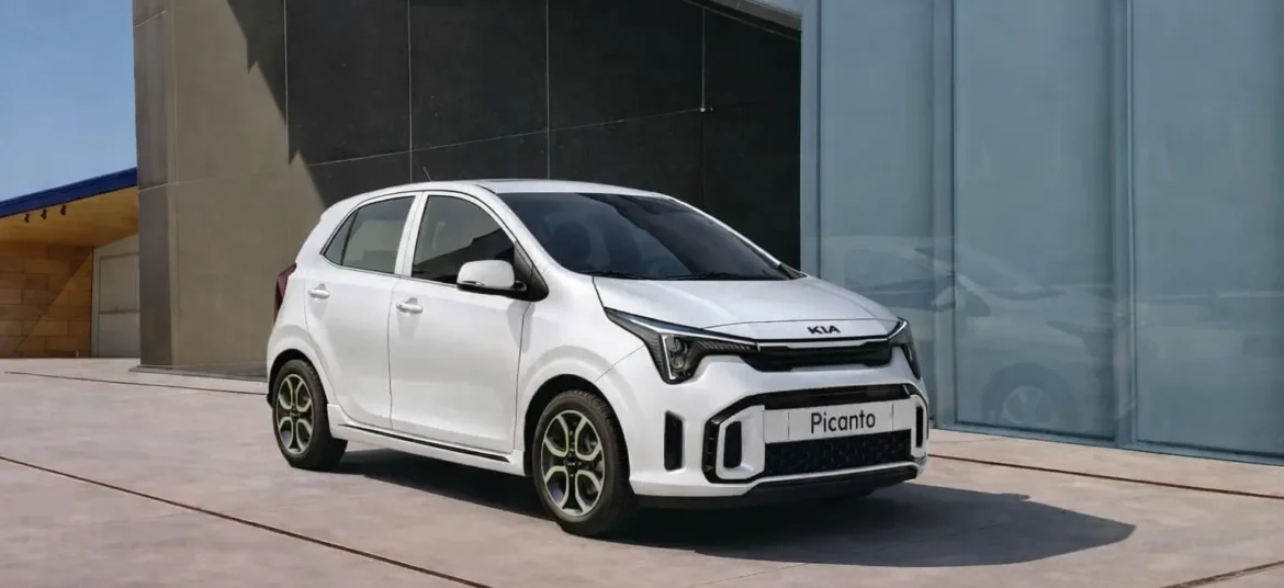 A white color picanto hatchback car parked in front of a glass wall