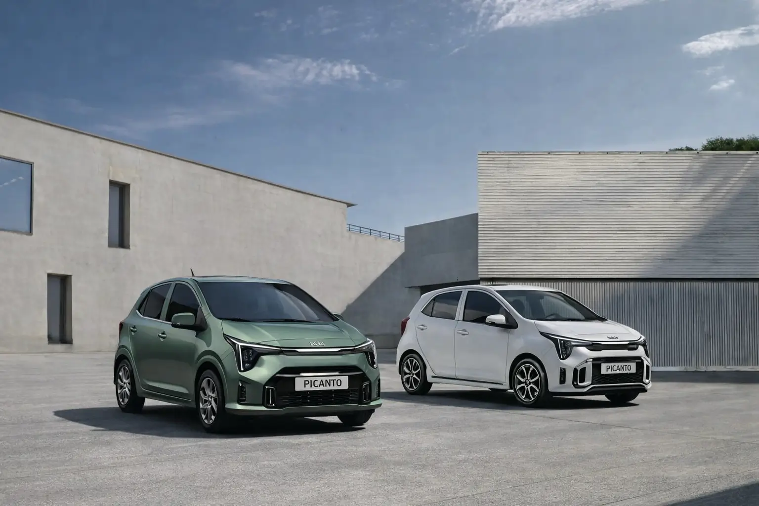 Two Picanto hatchbacks parked in front of box type building