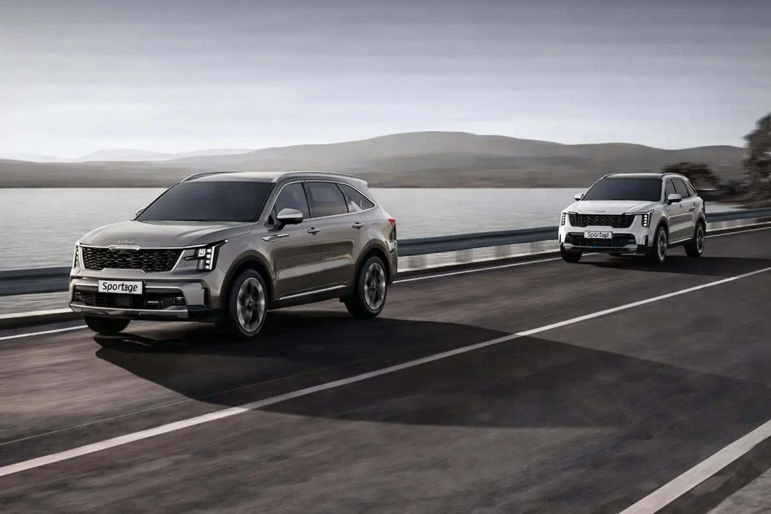 Two kia sportage suv's in a highway by a lake and travelling with Lane following Assist option